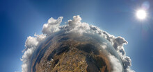 Aerial view from high altitude of little planet with distant city covered with puffy cumulus clouds flying by before rainstorm. Airplane point of view of landscape in cloudy weather