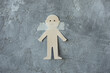 Photo of concept of illegal deprivation of rights of child, paper cut sad man sticking with adhesive tape on gray smeared plaster wall. Prohibition of speech freedom, censorship, food ban