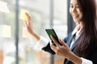 © Natee Meepian - Closeup image of a businesswoman using mobile phone in office