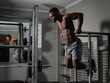 Leinwandbild Motiv Handsome afro american man doing parallel bars exercise in gym. 