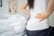 © PBXStudio - Woman suffering from back pain in bed health care and problem concept