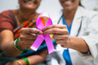 © WESTOCK - close up shot of doctor and patient showing breast cancer symbol by to camera at hospital - concept of illness, recovery and medicare