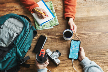 Family planning vacation trip. Girl searching travel destination and routes using navigation map on mobile phone. Charging smartphone with power bank. Using technology while travelling