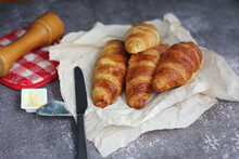A Pile Of Delicious Fresh Croissants Served With Butter On A Gray Table.