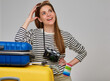 © Yuriy Shevtsov - Smiling woman with photo camera, sunglasses and passport leaning on travel bag looking up and dreaming for new journey.