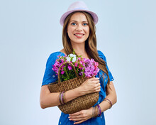 Woman Wearing Hipster Hat Holding Straw Bag With Flowers.