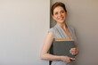 © Yuriy Shevtsov - Smiling woman teacher holding books. portrait with copy space.