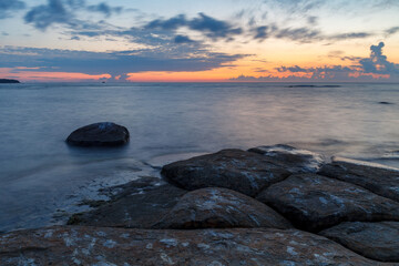 Wall Mural - Boulders and rocks in the surf on coast of the Baltic sea at sunset, long exposure