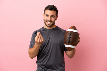 Wall Mural - Young caucasian man playing rugby isolated on pink background making money gesture