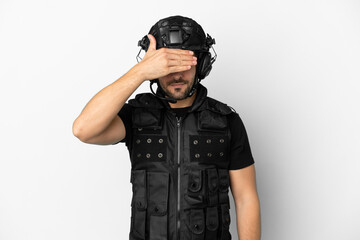 Poster - Young caucasian swat isolated on white background covering eyes by hands. Do not want to see something