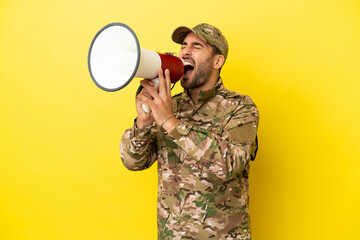 Wall Mural - Military man isolated on yellow background shouting through a megaphone