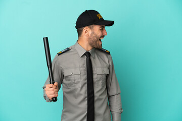 Wall Mural - Young security man isolated on blue background laughing in lateral position