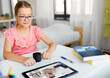 © Syda Productions - school, education and distance learning concept - little student girl in headphones with tablet computer having online class at home from top
