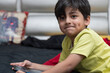 © IndiaPix - Close-up portrait of a cute boy child lying on bed with a smartphone