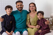© IndiaPix - Happy family sitting together on sofa at home