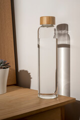 glass water bottle with wooden lid, hush shadows, drinking water and healthy lifestyl concept