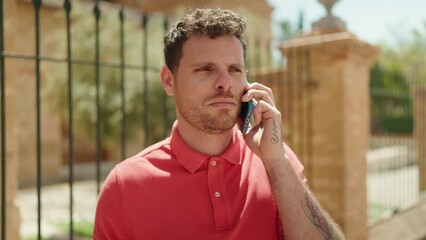 Poster - Young hispanic man smiling confident talking on the smartphone at street