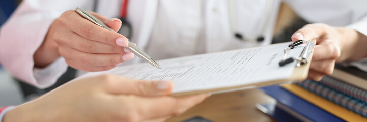 Female doctor and patient signing medical contract