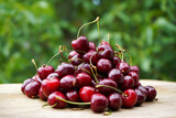 Heap of fresh sweet cherries on wooden cutting board with natural background.    