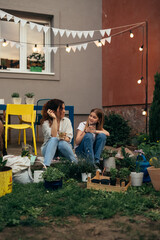 Wall Mural - mother and daughter talking in backyard. they ar gardening flowers