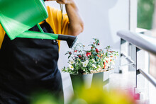 Senior Woman Watering Potted Flower