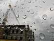 Regentropfen auf einer Scheibe mit Blick auf eine Baustelle symbolisch für verregnete Baubranche