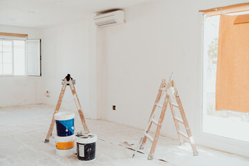 ladders and pots on white room at construction site. Painting walls. Home improvement, renovation