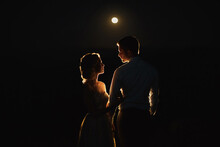 Moonlight Highlights The Silhouettes Of The Bride And Groom In The Mountains