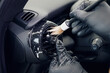 © svetlichniy_igor - Cleaning the car interior with a brush. Auto detailing worker cleaning car interior, car detailing concept. Selective focus. Dust removal from the dashboard of the car with a brush