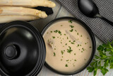 Fototapeta Kuchnia - Delicious white asparagus cream soup on wooden background