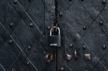 Padlock On An Old Forged Black Metal Door With Stripes And Rivets. Fragment Of The Boim Chapel In Lviv, Ukraine. Vintage Background Closeup. Closed Passage And Protection Concept.
