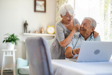 Happy Senior Couple Using Laptop At Home
