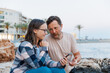 © Enigma - Dad and daughter look at the phone on a walk through the evening city by the sea