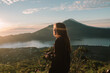 © Karyna Bartashevich/Stocksy - photo of a girl in profile during a beautiful sunset in Bali against the backdrop of a natural lake and mountains during sunset