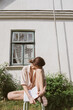 © Karyna Bartashevich/Stocksy - Portrait of a girl with a book sitting in the garden near the house