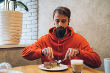 Man Eating Cake In Cafe