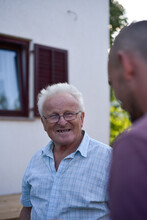 Smiling Elderly Man While Chatting With Adult Son