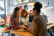 © Manu Prats/Stocksy - Diverse women paying phone in clothes shop