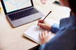 © ALTO IMAGES/Stocksy - Woman writing in notepad while studying on laptop