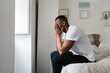 © Ezequiel Giménez/Stocksy - Black man rubbing eyes after awakening in bedroom