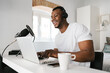 © Ezequiel Giménez/Stocksy - Cheerful black man using laptop during podcast