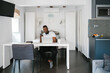 © Ezequiel Giménez/Stocksy - Content black freelancer using smartphone and laptop