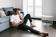 © Ezequiel Giménez/Stocksy - Black male listening to music on floor