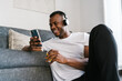 © Ezequiel Giménez/Stocksy - Glad black man browsing smartphone in morning