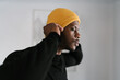© Ezequiel Giménez/Stocksy - African American male adjusting hat