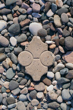 Close Photo Of Pebbles On Seashore With A Figured Slab In The Center
