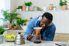 Young Black Man Brewing Filter Coffee In A Kitchen
