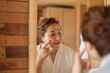 © Marc Tran/Stocksy - Young woman applying moisturizer on her face
