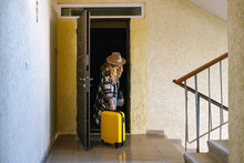 Female Tourist Leaving Apartment With Baggage 