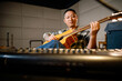 © ZQZ Studio/Stocksy - Man playing guitar in his studio
